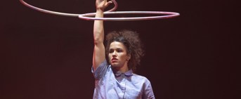 Une femme avec une main en l'air faisant tourner deux cerceaux 