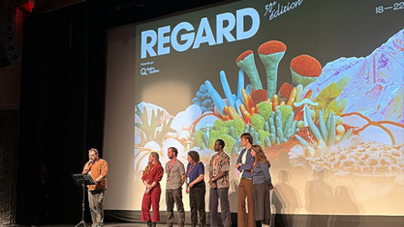 Six artisans de cinéma sur une scène à une remise de prix avec un présentateur