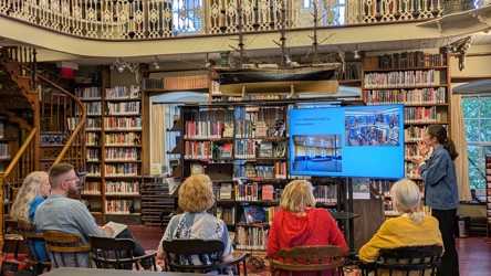 Une personne fait une présentation sur écran à un groupe constitué principalement d'aînés, dans une bibliothèque